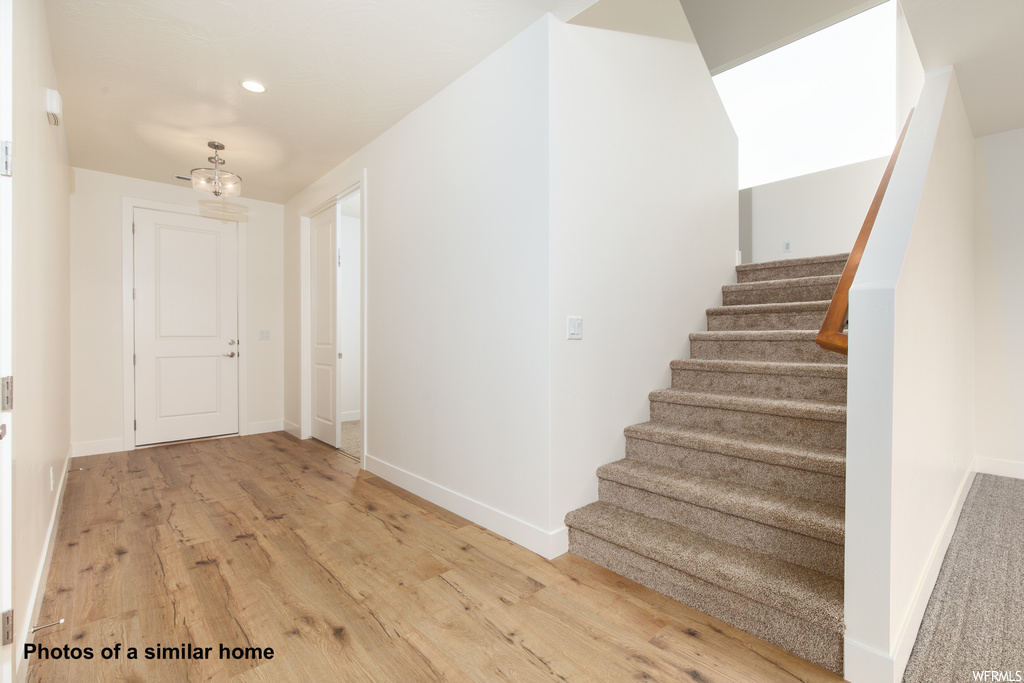 Stairway with light hardwood / wood-style flooring