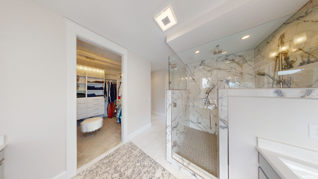 Bathroom with vanity, a shower with shower door, and tile floors