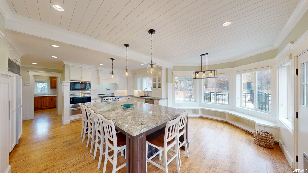 Dining space featuring sink, crown molding, and light hardwood / wood-style flooring