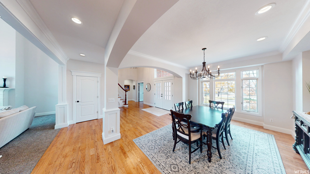 Dining area featuring ornamental molding, an inviting chandelier, and light hardwood / wood-style floors