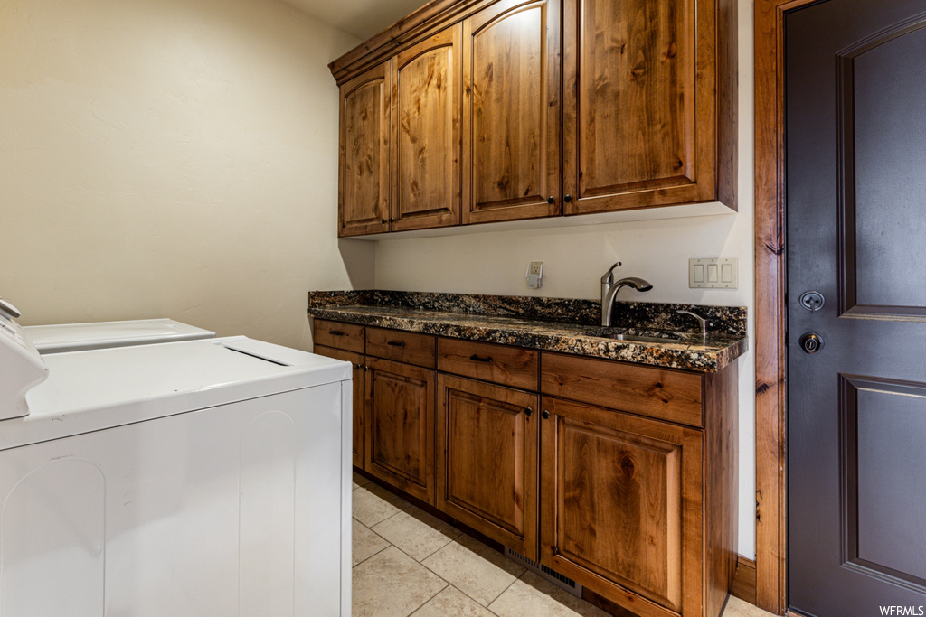Laundry area with cabinets, sink, washing machine and dryer, and light tile floors