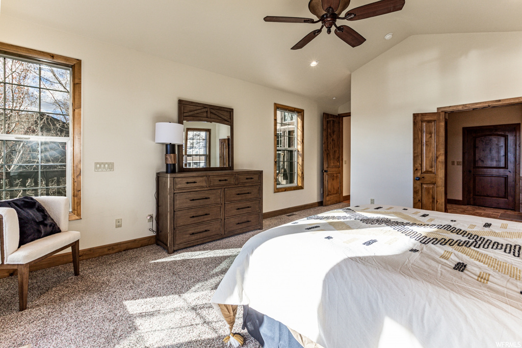 Carpeted bedroom featuring lofted ceiling and ceiling fan