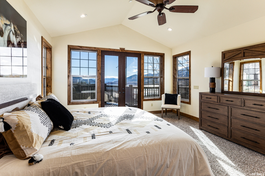 Bedroom with access to outside, ceiling fan, multiple windows, and vaulted ceiling