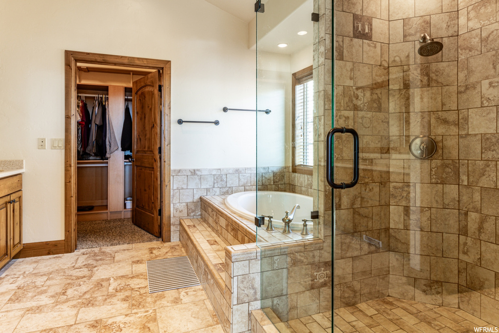 Bathroom featuring tile floors, plus walk in shower, and vanity