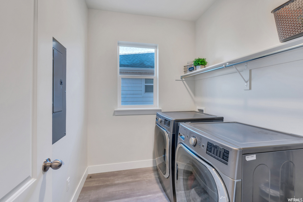 Clothes washing area with washing machine and clothes dryer, washer hookup, and hardwood / wood-style floors