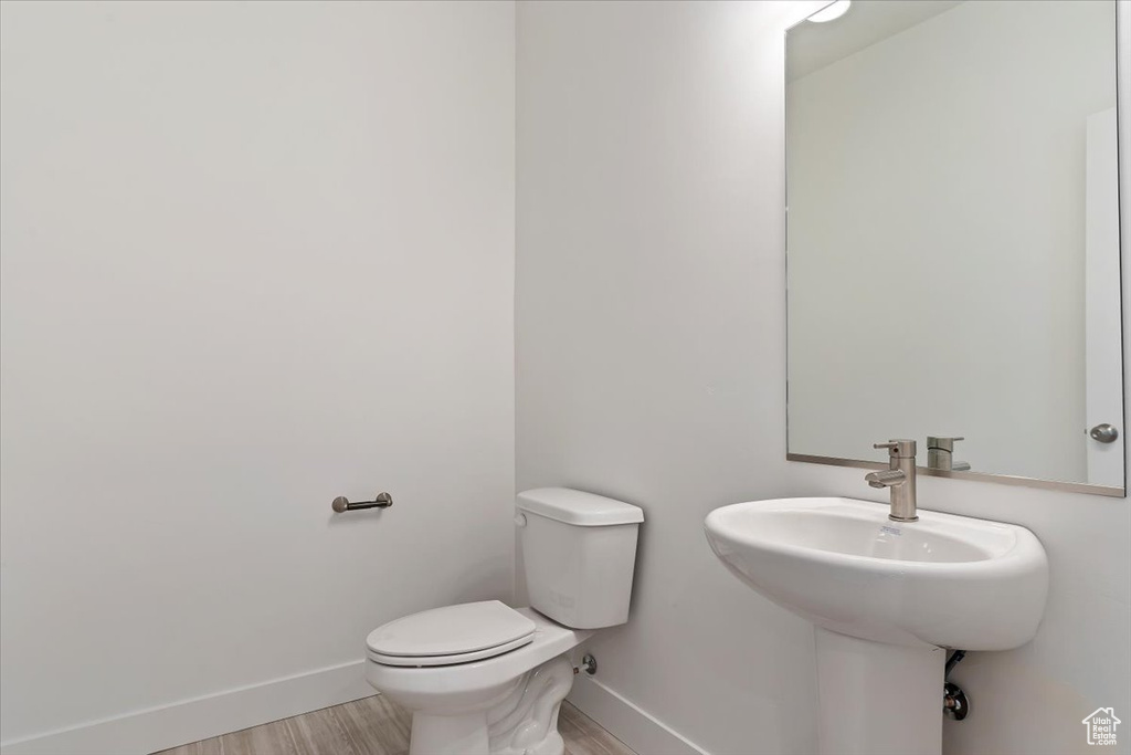 Bathroom with sink, toilet, and hardwood / wood-style flooring