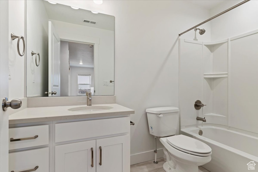 Full bathroom featuring bathtub / shower combination, toilet, and vanity with extensive cabinet space
