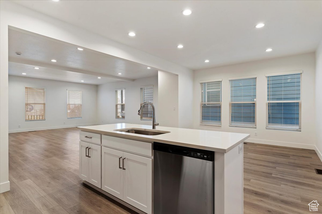 Kitchen with sink, dishwasher, light hardwood / wood-style floors, and white cabinets