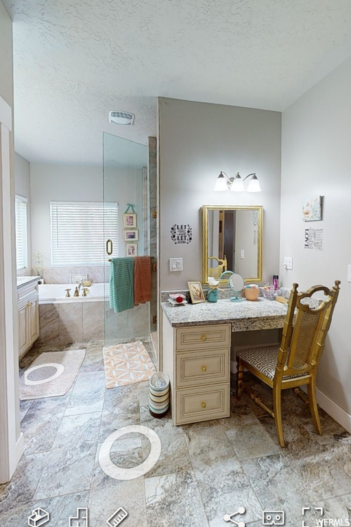 Bathroom featuring independent shower and bath, vanity, a textured ceiling, and tile floors