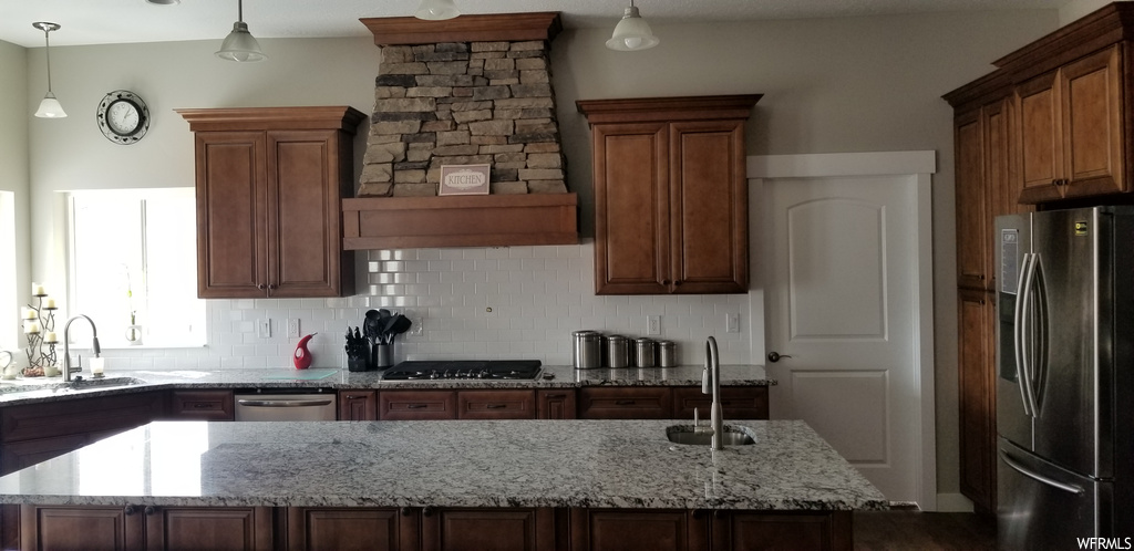 Kitchen featuring sink, hanging light fixtures, tasteful backsplash, and stainless steel appliances