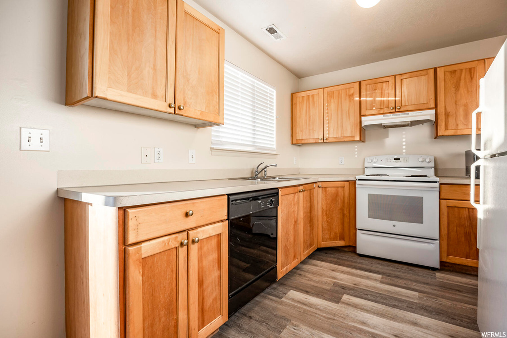 Kitchen featuring white appliances, dark hardwood / wood-style flooring, and sink