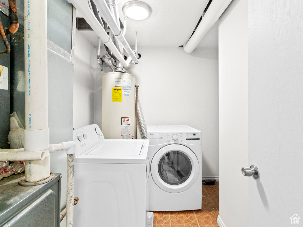 Clothes washing area featuring independent washer and dryer, gas water heater, and light tile flooring