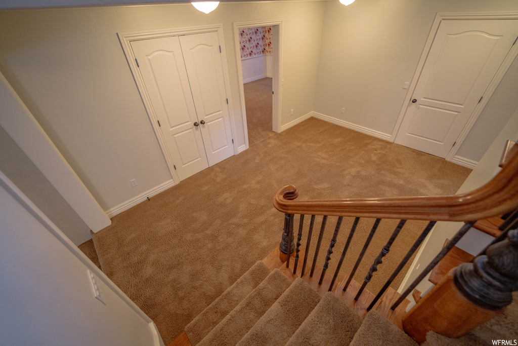 Stairway featuring light colored carpet