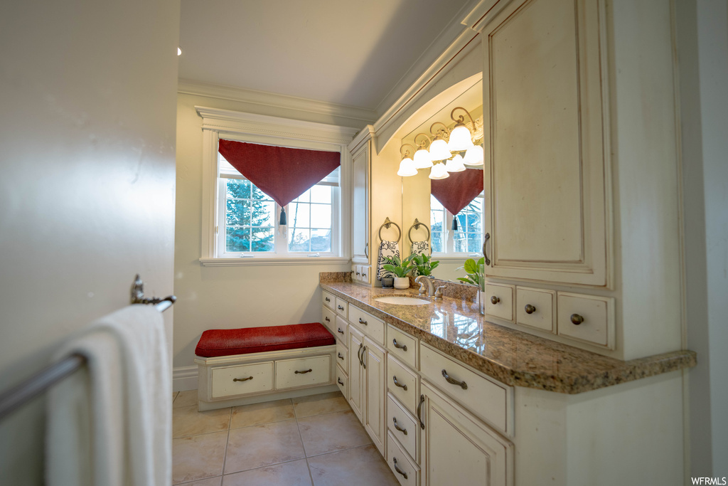 Bathroom with vanity, tile flooring, and crown molding
