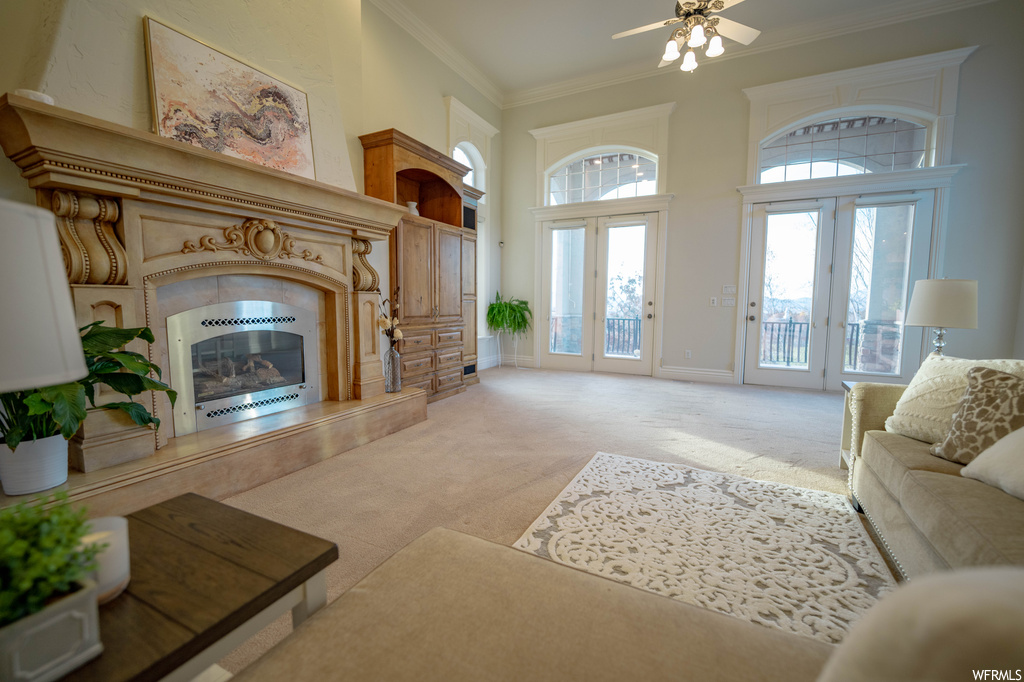 Living room featuring ornamental molding, ceiling fan, light colored carpet, and french doors