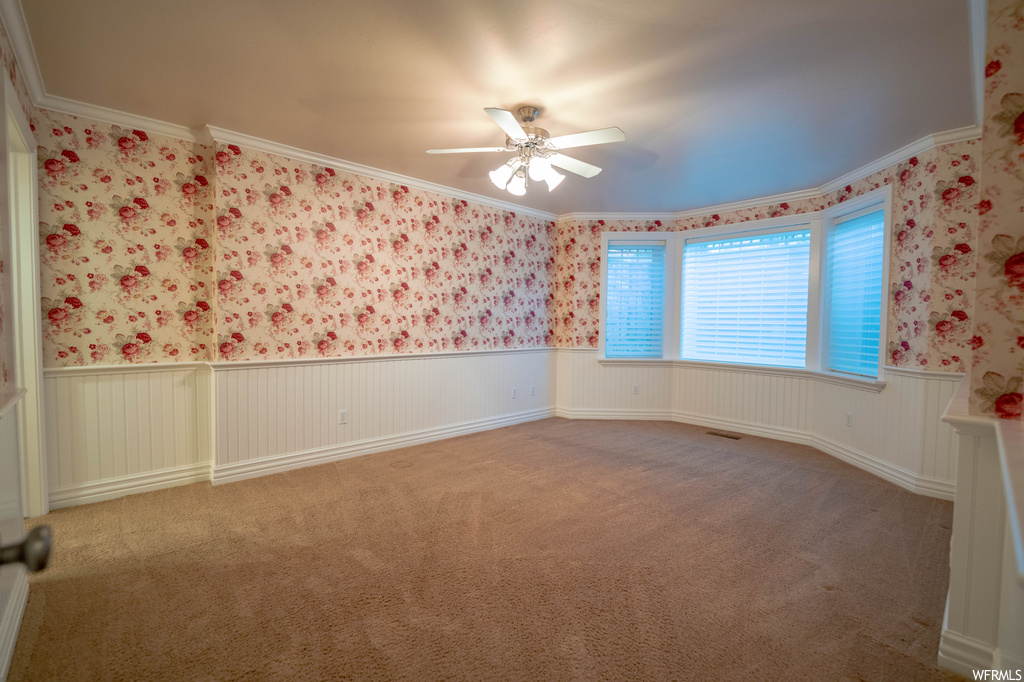 Carpeted empty room with ornamental molding and ceiling fan