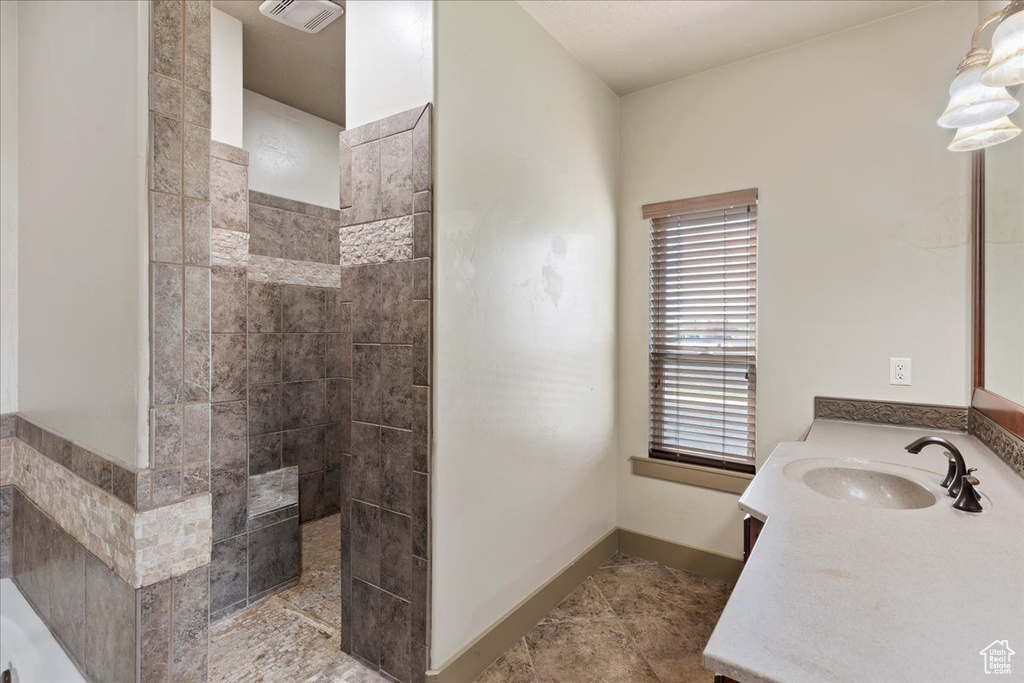 Bathroom with a bath to relax in, tile floors, and vanity