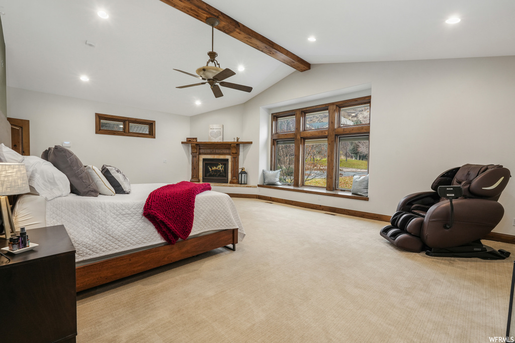 Carpeted bedroom featuring lofted ceiling with beams and ceiling fan