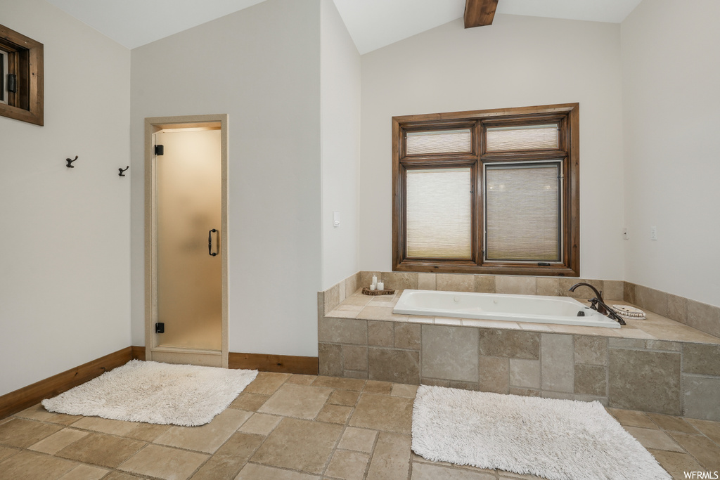 Bathroom featuring vaulted ceiling with beams, tile flooring, and plus walk in shower