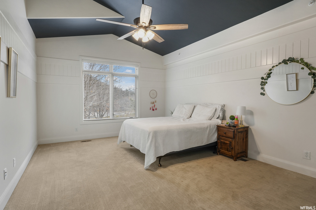 Bedroom featuring lofted ceiling, light colored carpet, and ceiling fan