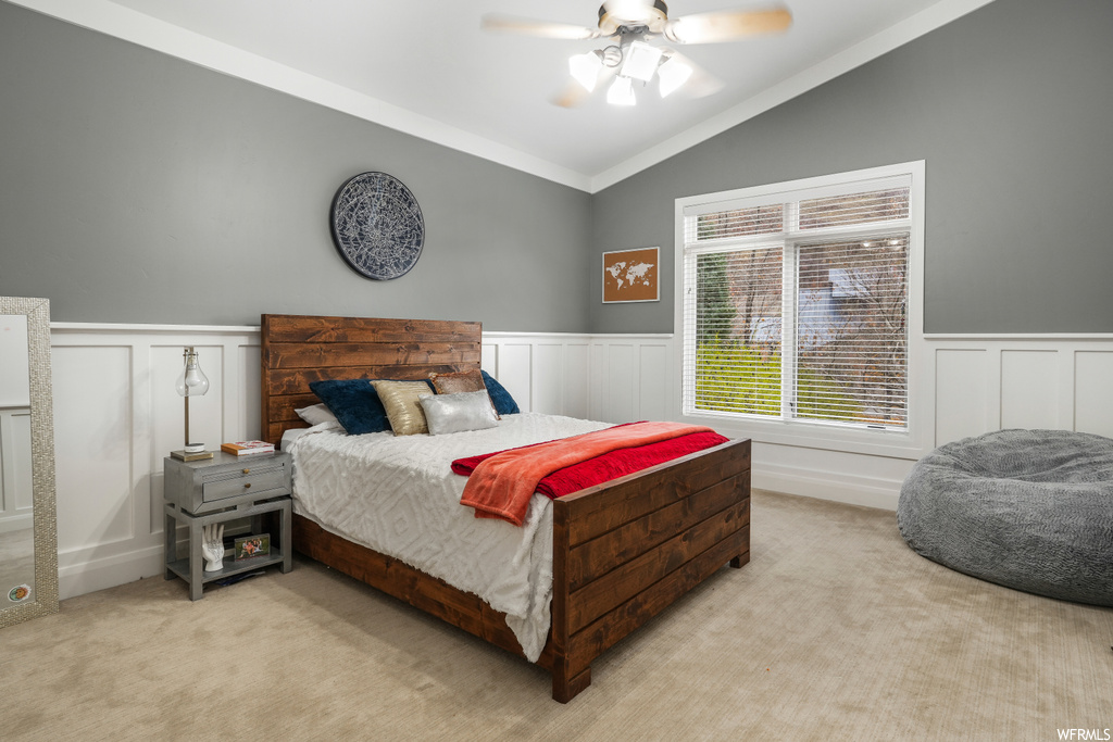 Carpeted bedroom featuring lofted ceiling, ceiling fan, and crown molding