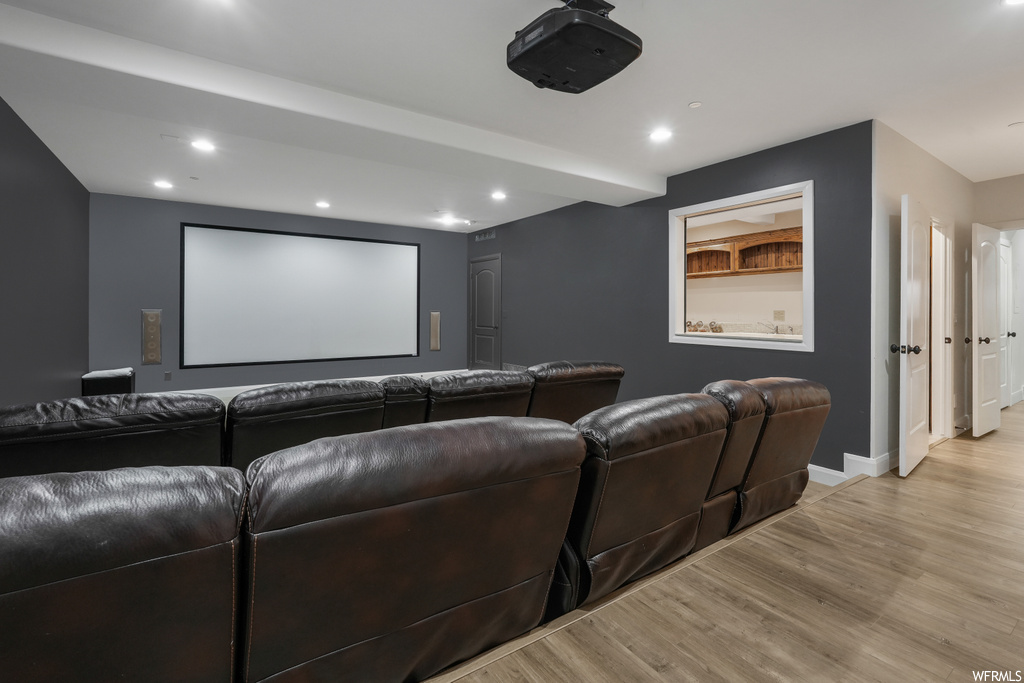 Home theater with light wood-type flooring
