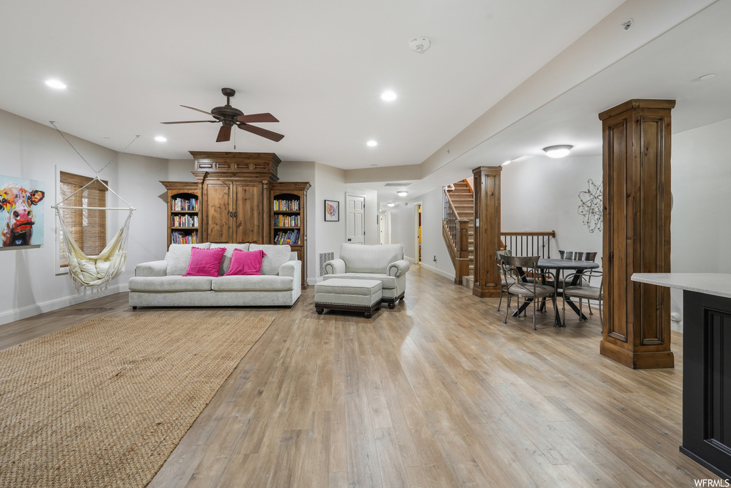 Living room featuring light hardwood / wood-style flooring, ceiling fan, and decorative columns