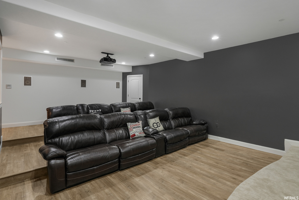 Home theater room with light wood-type flooring