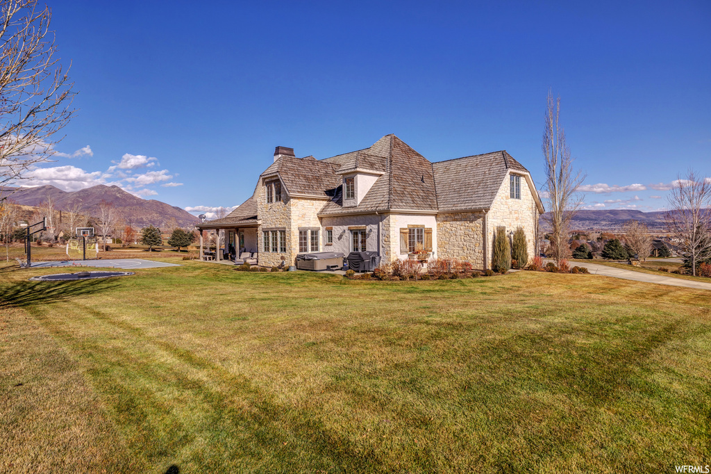 French country home featuring a front lawn and a mountain view