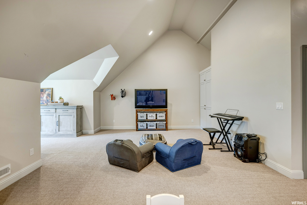 Living area featuring lofted ceiling and light carpet