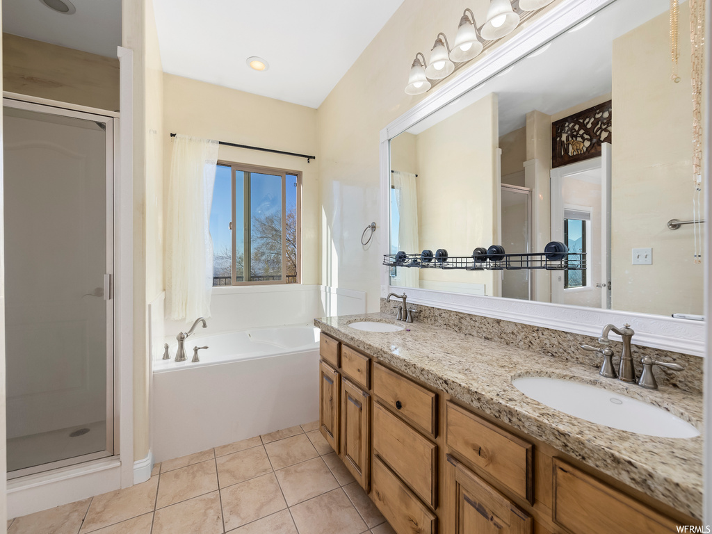 Bathroom featuring dual sinks, independent shower and bath, tile floors, and large vanity