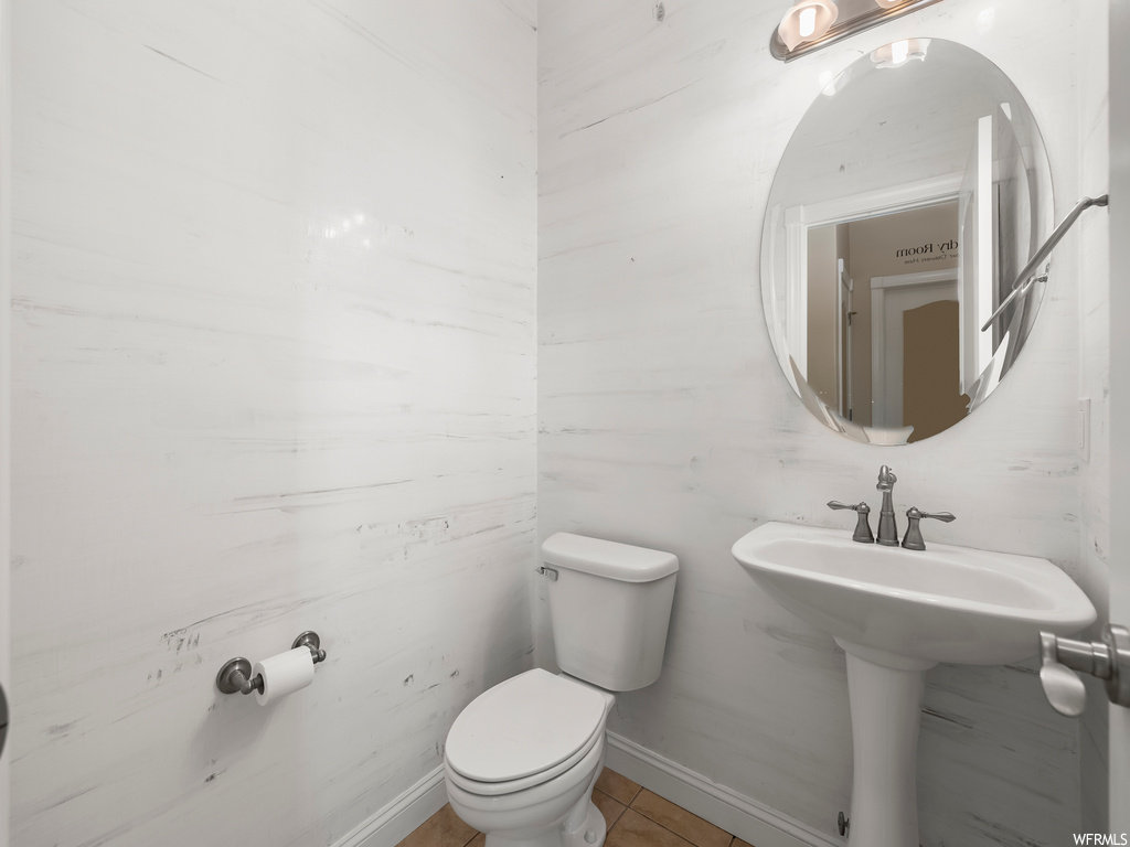 Bathroom featuring toilet, tile floors, and sink