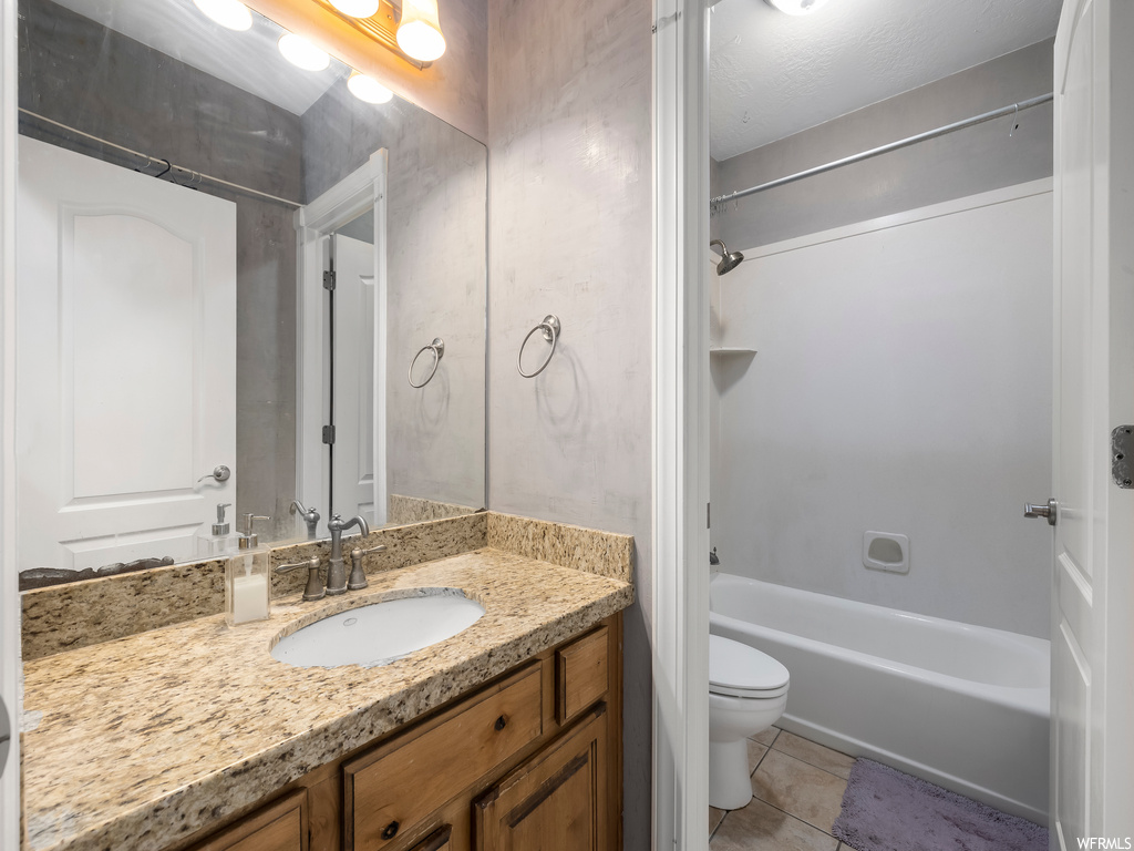 Full bathroom with toilet, tile floors, shower / bathtub combination, and oversized vanity