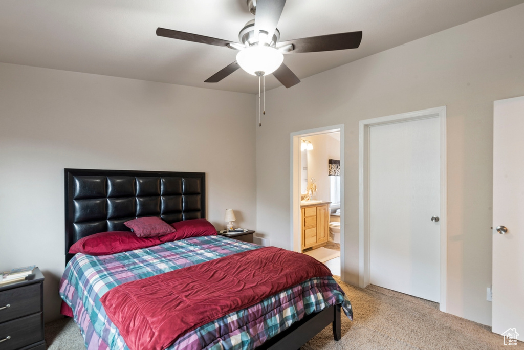 Carpeted bedroom featuring ceiling fan and ensuite bathroom