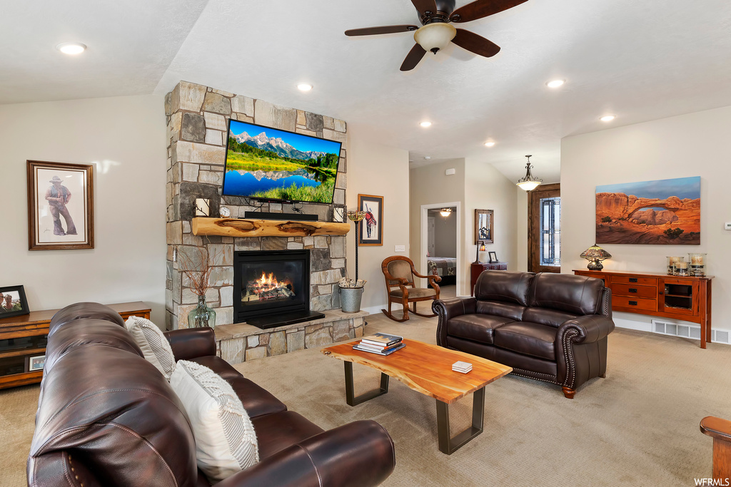 Living room featuring light colored carpet, ceiling fan, and a fireplace