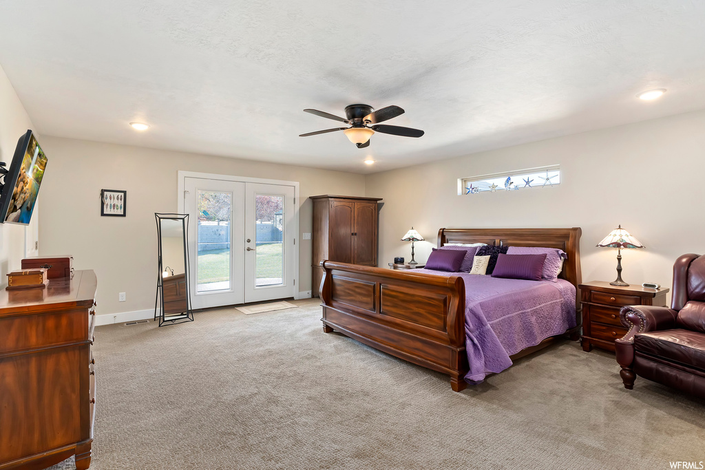 Carpeted bedroom with ceiling fan, multiple windows, access to outside, and french doors