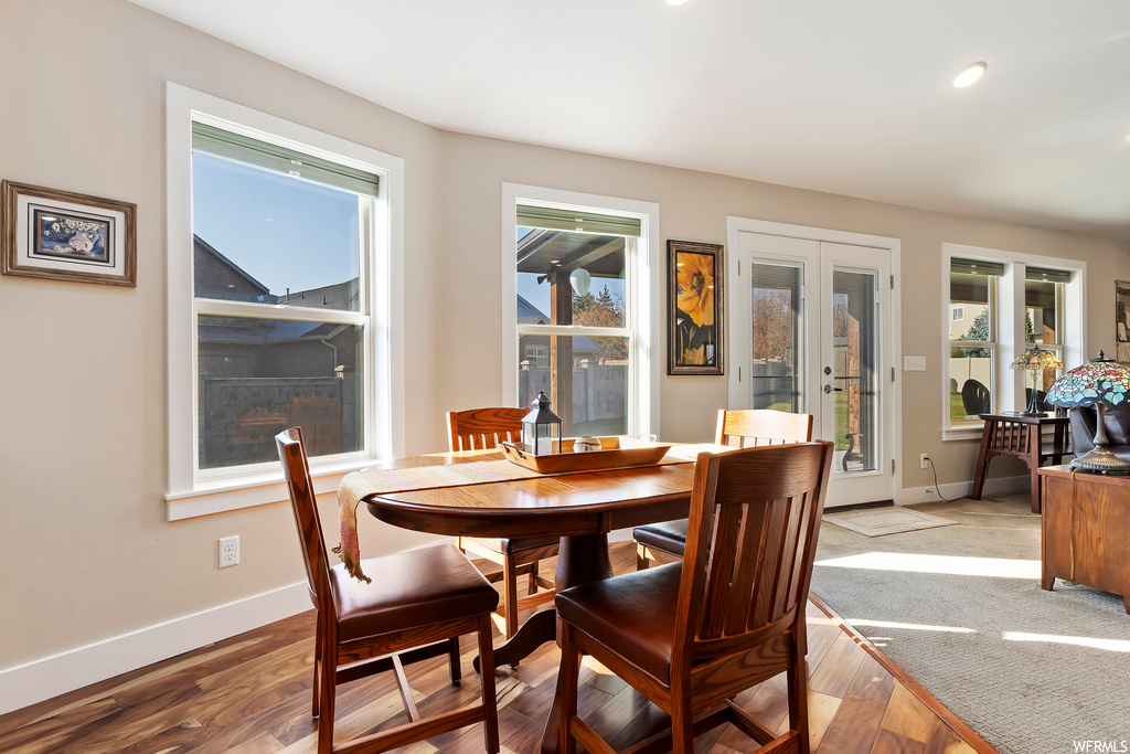 Dining room with a healthy amount of sunlight, light hardwood / wood-style flooring, and french doors