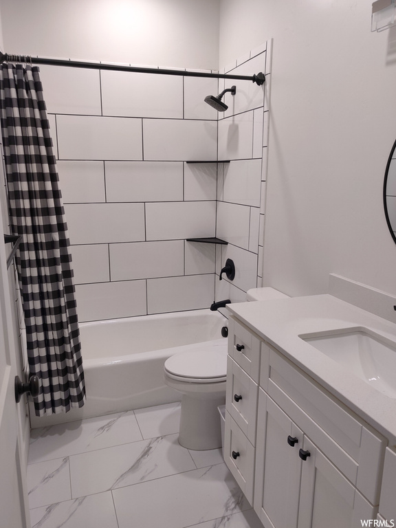 Full bathroom featuring toilet, tile floors, shower / bath combo, and vanity