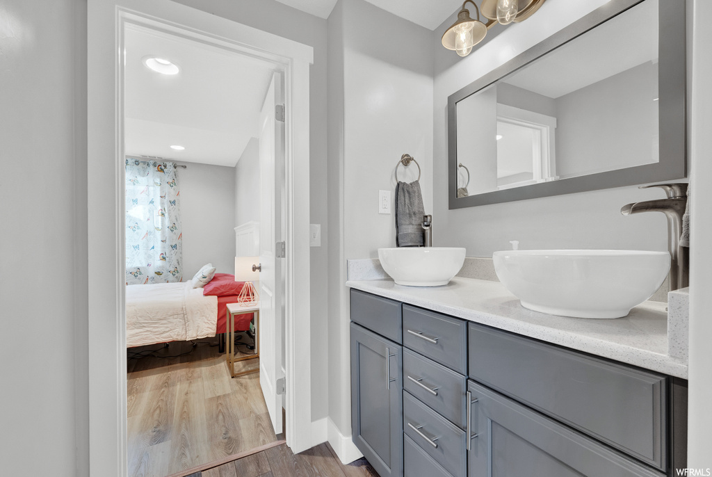 Bathroom with double sink, hardwood / wood-style floors, and large vanity