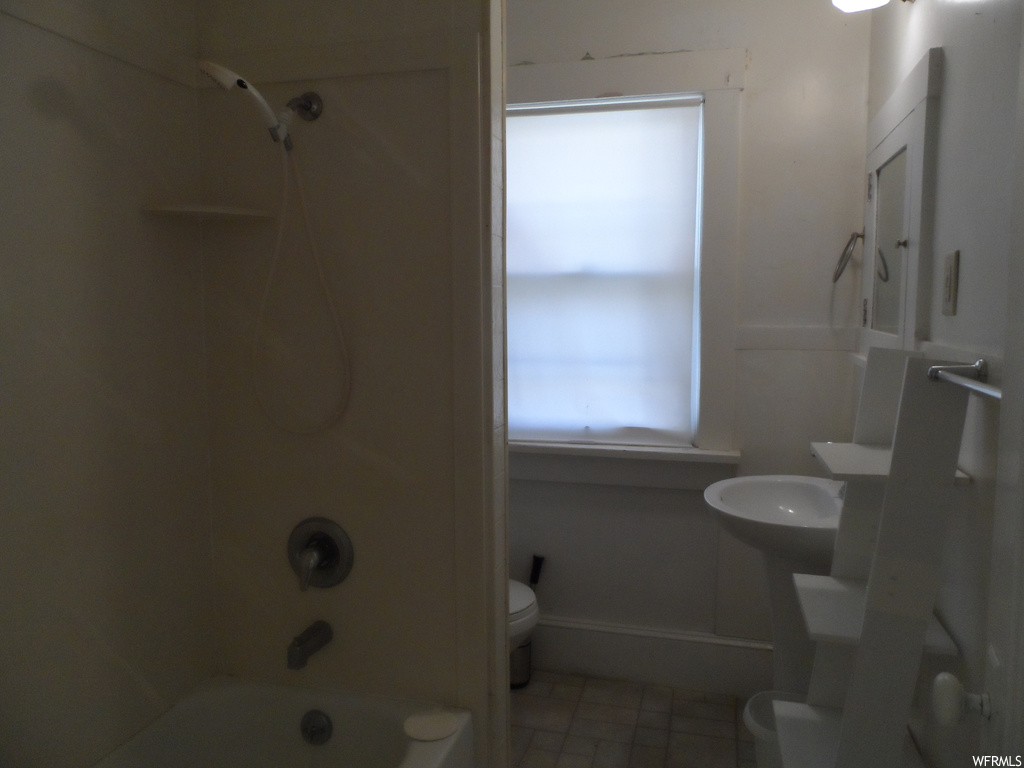 Full bathroom with toilet, tile floors, sink, and shower / bath combination
