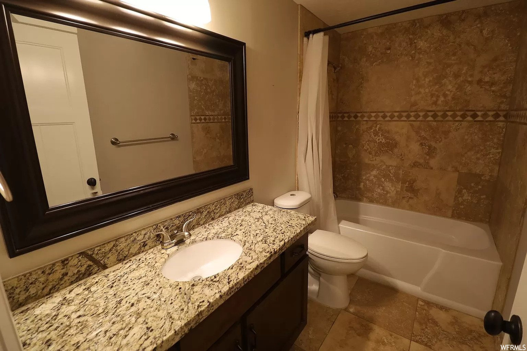 Full bathroom featuring vanity, toilet, tile flooring, and shower / tub combo