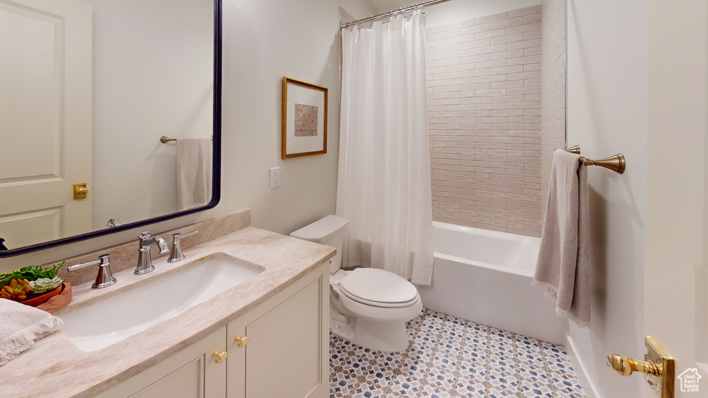 Full bathroom with tile patterned flooring, shower / tub combo, vanity, and toilet