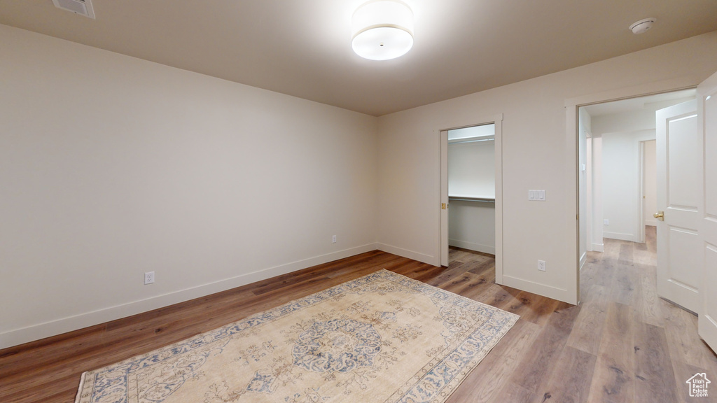 Bedroom featuring a closet, light hardwood / wood-style floors, and a walk in closet