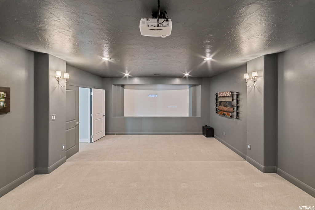 Carpeted cinema room featuring a textured ceiling