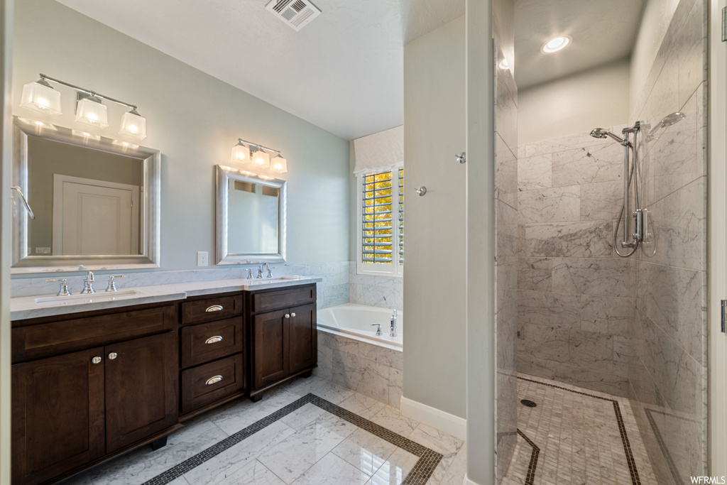 Bathroom with separate shower and tub, double sink vanity, and tile flooring