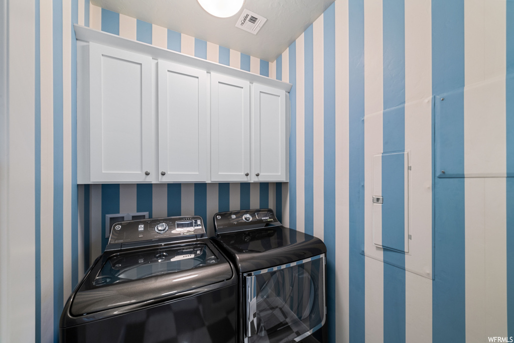 Laundry room with cabinets, washing machine and dryer, and hookup for a washing machine