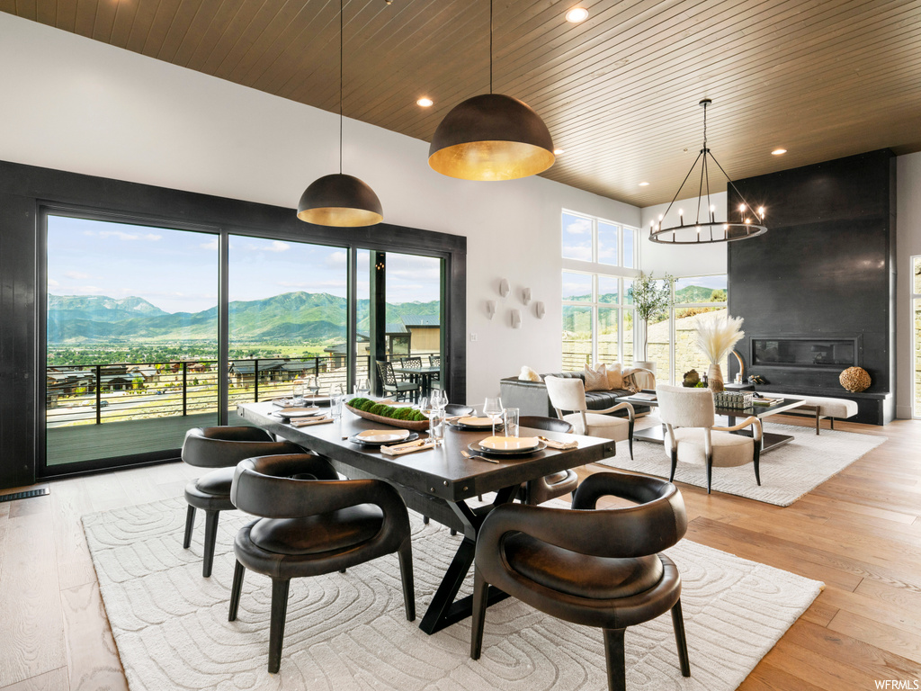 Dining area featuring an inviting chandelier, wood ceiling, light hardwood / wood-style floors, and a mountain view