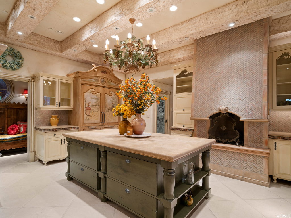 Kitchen featuring beam ceiling, pendant lighting, an inviting chandelier, tasteful backsplash, and a kitchen island