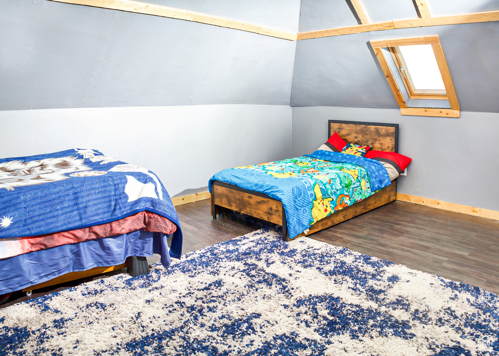Bedroom featuring dark hardwood / wood-style floors and lofted ceiling