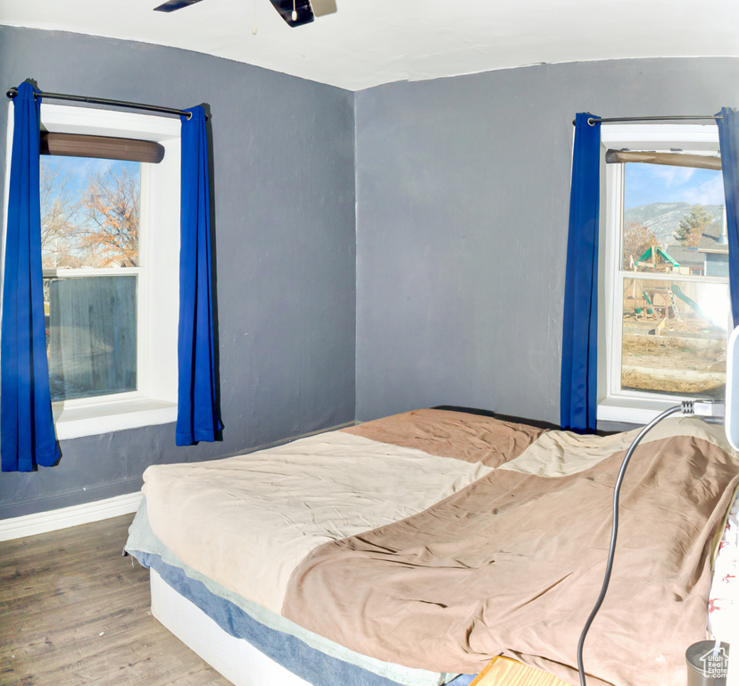 Bedroom with ceiling fan and dark wood-type flooring